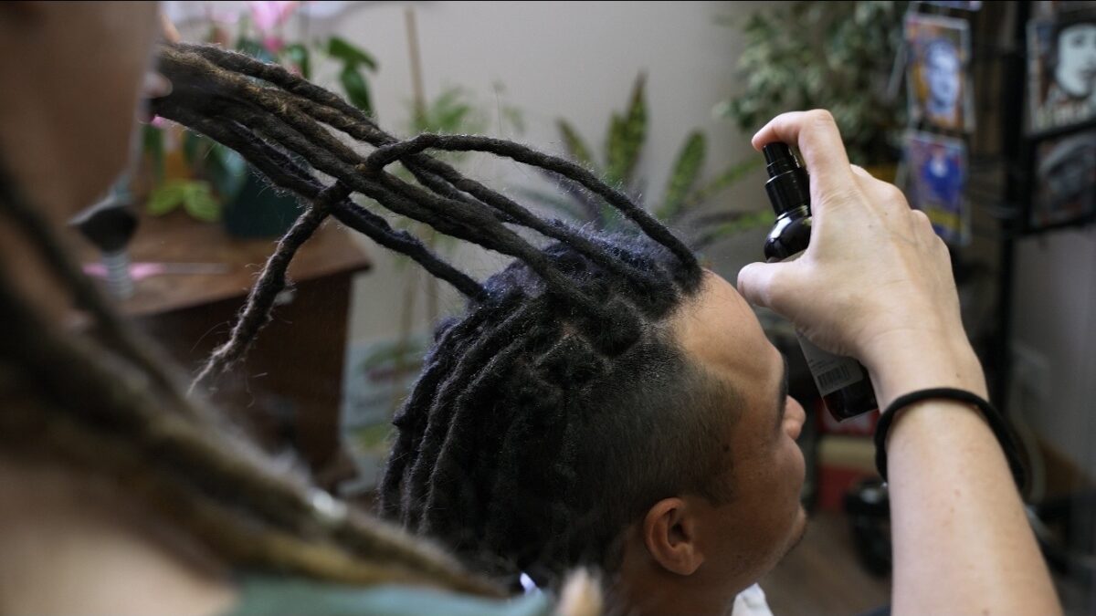 Entretien des dreadlocks en été avec application d'un soin hydratant sur les locks naturelles